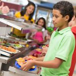 Middle school students getting lunch items in cafeteria line