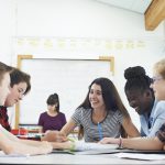 Group Of Teenage Students Collaborating On Project In Classroom