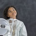 Pretty schoolgirl in astronaut costume
